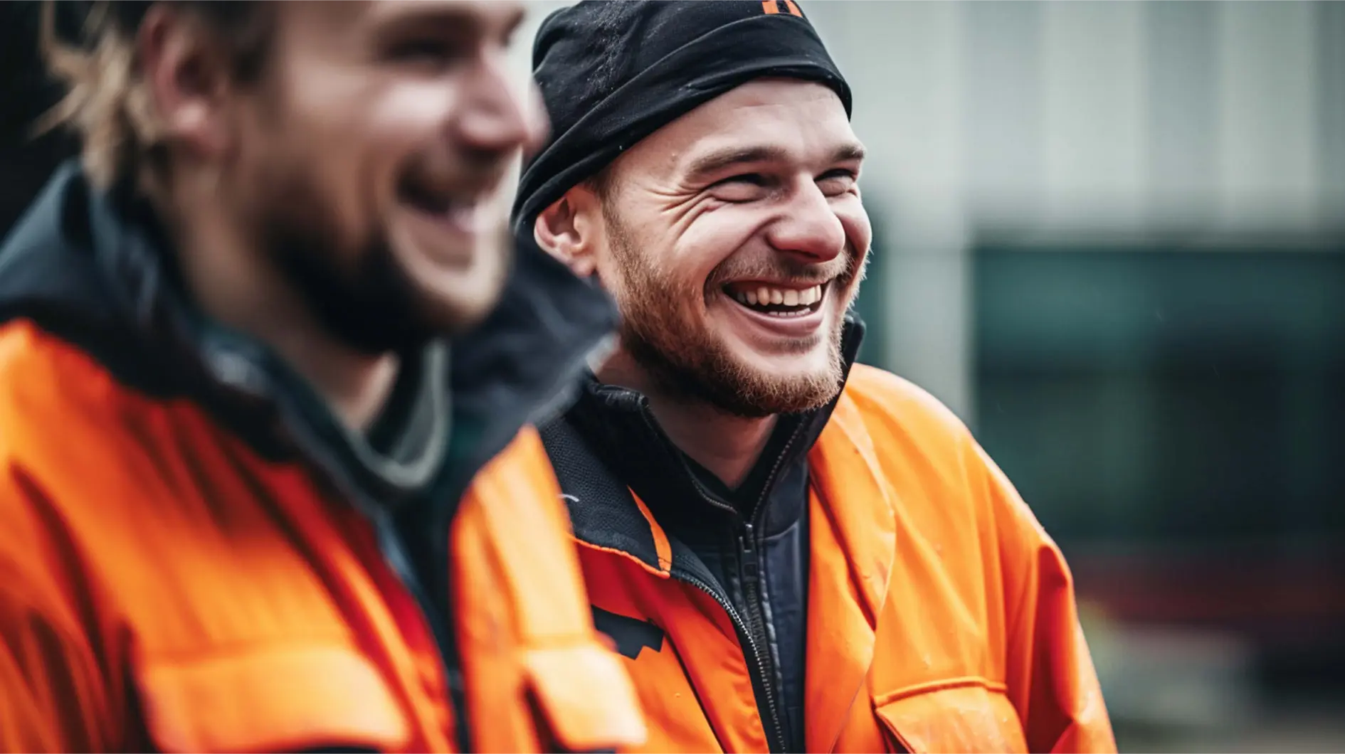 Two happy workers in orange jackets